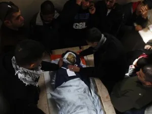 فلسطينيون يلتفون حول جثة الشاب محمد عصفور في مشرحة مستشفى في رام الله
