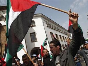 متظاهرون يرفعون علم فلسطين في مسيرة أمام البرلمان المغربي بالرباط 
