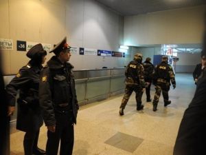 عناصر امن روسيون (يمين) يسرعون داخل مطار دوموديدوفو الدولي في موسكو بعيد الانفجار الاثنين