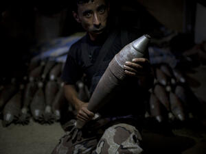 A rebel fighter holds an improvised mortar shell, one of many stacked at a factory in the city of Aleppo, Syria's commercial capital, on July 7, 2013. (Source: AFP/JM LOPEZ)