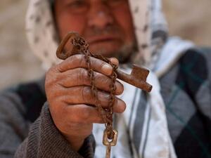 An old Palestinian man still holds the key to his old house taken from him in 1948.