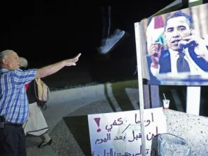 اسرائيل يوجه حذاءه الى صورة الرئيس الاميركي 