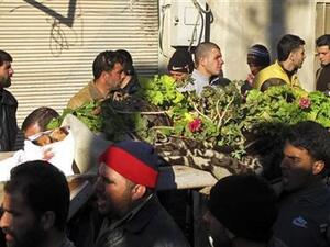 رجال يشيعون جنازة خمسة مدنيين قتلوا جراء قصف الجيش السوري لبلدة القصير في حمص 
