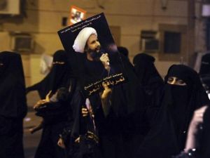 متظاهرة ترفع صورة الشيخ نمر النمر خلال احتجاج في القطيف
