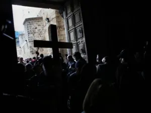 حجاج مسيحيون يدخلون كنيسة القيامة رافعين صلبانا

