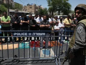 فلسطينيون يؤدون الصلاة خلف حاجز للجيش الاسرائيلي خارج المدينة القديمة في القدس 
