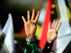 A Turkish muslim woman makes the "Rabia sign" during a rally on August 25, 2013. (AFP)
