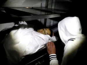 احد اقارب الفتى الفلسطيني وجيه الرمحي يلقي نظرة على جثته في مخيم الجلزون بالضفة الغربية
