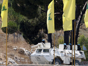 UN peacekeepers patrol as Hezbollah flags fly on July 23 in the southern Lebanese city of Marjayoun. (AFP / MAHMOUD ZAYYAT)