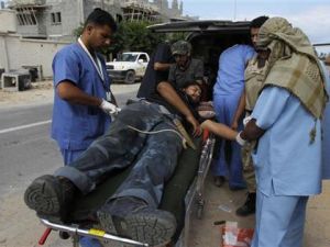 مسعفون يعالجون مقاتلا مناهضا للقذافي اصيب في القتال في وسط سرت 
