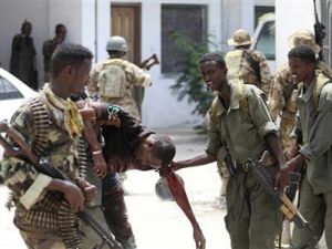 جنود صوماليون يساعدون رجلا أصيب في انفجار في مقديشو يوم الأحد
