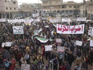 متظاهرون يشاركون في مسيرة ضد الرئيس السوري بشار الاسد عقب صلاة الجمعة بالقرب من أدلب
