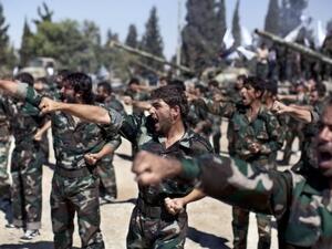 Members of rebel brigades parade at a former military academy north of Aleppo. Syrian rebels have expressed disdain for US President Barack Obama after he backed away from striking over alleged chemical weapons attacks, while saying the world doesn't really care about Syria. (AFP)