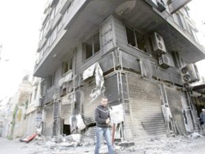 سوري يسير قرب مبنى مدمر 