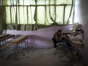 A rebel fighter takes aim inside a destroyed school in Aleppo, on July 14. 2013. (source: AFP / JM LOPEZ)