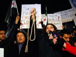 سوريون يتظاهرون استنكارا لقصف حمص امام السفارة السورية في انقرة السبت