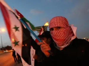 متظاهر سوري يحمل العلم الوطني خلال تظاهرة امام السفارة السورية في العاصمة الاردنية