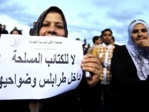 امراة ليبية ترفع لافتة خلال تظاهرة في طرابلس تطالب برحيل المليشيات المسلحة