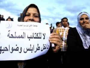 امراة ليبية ترفع لافتة خلال تظاهرة في طرابلس تطالب برحيل المليشيات المسلحة