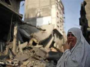 امراة فلسطينية تقف امام منزل مدمر اثر غارة اسرائيلية في غزة