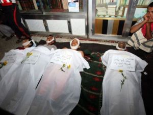 شاب يمني يجلس بجانب جثث متظاهرين قتلوا في ساحة التغيير في صنعاء الخميس