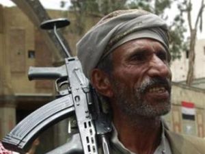 احد افراد القبائل الموالية للزعيم صادق الاحمر يحمل بندقيته لدى وقوفه لحماية منزل الاحمر في صنعاء
