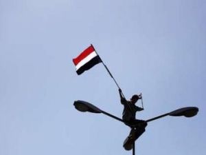 متظاهر يرفع علم اليمن على اعمدة الكهرباء