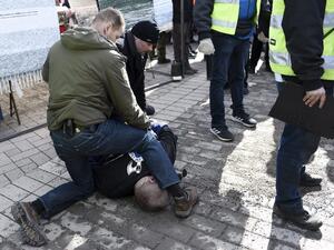 صورة نشرتها الوكالة الفنلندية "ليتيكوفا" تناقلتها وسائل إعلامية محلية رجلا مطروحا أرضا وحارسين يمسكان به 