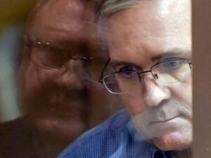 عنصر المارينز السابق بول ويلان ينظر من خلف قفص زجاجي خلال محاكمته في قاعة محكمة في موسكو

