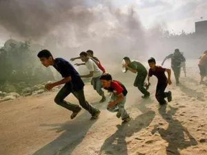 ارشيف/فلسطينيون في غزة يفرون من غارة اسرائيلية