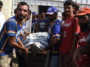 Pakistan rescuers shift the body of a passenger, who was killed in a train accident, to a mortuary in Karachi on November 3, 2016. (AFP/Rizwan Tabassum)