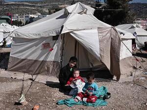 Afghan refugees rest next to their tent at the reception center for refugees in Schisto, near Athens, Greece, February 25, 2016. (AFP/File) 