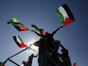 Palestinians wave flags during a rally. (AFP/File)