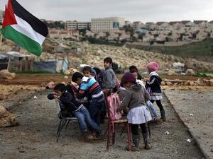 Palestinian bedouin children from the Abu Nawar community attend a class in the West Bank town of al-Azariya near the Jewish settlement of Maale Adumim (background), east of Jerusalem, on February 23, 2016. (AFP/Ahmad Gharabli)