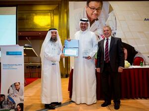 Dr. Abdullah Al Ansari (center), Deputy Chief of Medical, Academic and Research Affairs for Surgical Services, collecting the Best Department Award on behalf of the Surgery Department from Professor Janahi (left) and Professor Hillhouse (right)