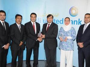 Shafqat Anwar, AUB's Deputy Group CEO, Operations & Technology, receiving the award from Ali Moosa, J.P. Morgan's Managing Director, MENA region