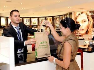 A customer receives purchases in a biodegradable bag at Abu Dhabi International Airport’s Duty Free