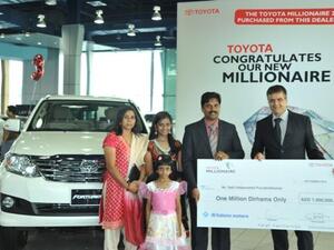 Andrew Squires presenting cheque to the Millionaire and family