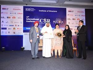 Khalil Saqer bin Gharib and Maryam Al Shamsi receive the award trophy from Mrs. Pankaja Gopinathrao Munde