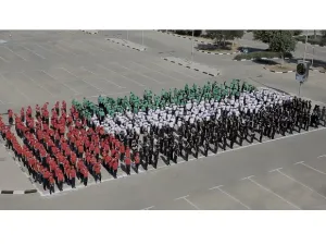 شارك أكثر من 600 طالب من مدرستي كويلا وجي اس اس الدولية تتراوح أعمارهم ما بين السابعة ولغاية الحادية عشر في تشكيل علم بشري بألوان زاهية.