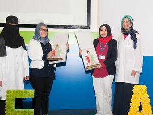 Dr. Manal Zaidan poses in a group photo with staff members during the celebration