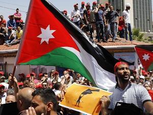 Jordanian protesters wave national flags and shout slogans during an anti-austerity rally, on June 6, 2018, in front of the Labor Union offices in Amman. (AFP)