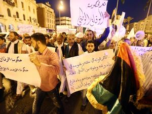 Pro-UN-backed government protesters hold placards and shout slogans during a demonstration in the Libyan capital Tripoli on April 1, 2016. (AFP/Mahmud Turkia)