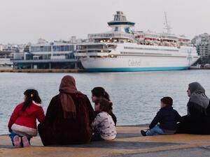 Refugee families sit on February 26, 2016 at a pier in the port of Piraeus, where hundreds of migrants and refugees, many from Syria stay temporarily. (AFP/Louisa Gouliamaki)