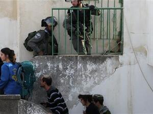 Israeli settlers under the escort of Israeli border police enter two homes in a building in Hebron. (AFP/File)