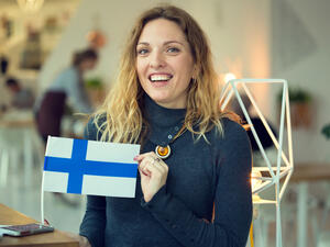 woman holds the flag of Finland. (Shutterstock/ File Photo)