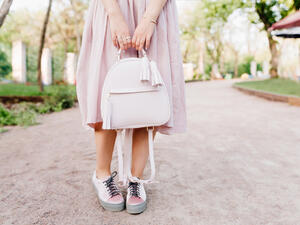 اختيار فستان باللون البيج الفاتح وتنسيقه مع حذاء باللون نفسه وحقيبة بيضاء كبيرة (shutterstock.com)
