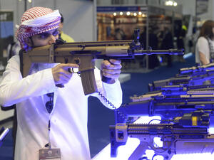 An Arab man in traditional clothes checks a new model of a machine gun visiting weapons exhibition. (Shutterstock/ File)
