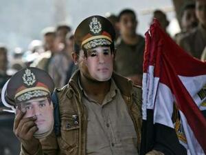 An Egyptian street vendor sells the country's national flag and masks of Egypt's, then Defence Minister but now current president, General Abdel Fattah al-Sisi. (AFP/File)