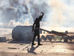 محتج يرتدي قناعا واقيا من الغاز يشارك في مظاهرات مناهضة للحكومة البحرينية في بلدة سترة جنوب المنامة
